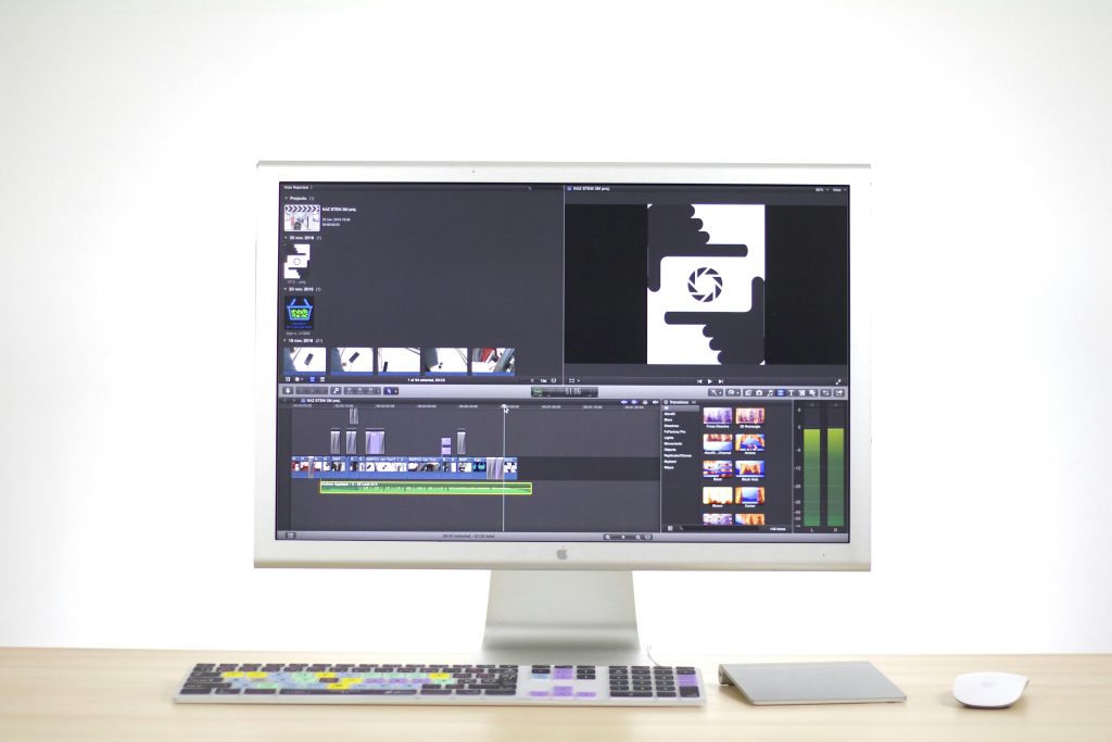 A sleek computer monitor displays video editing software in a modern workspace.